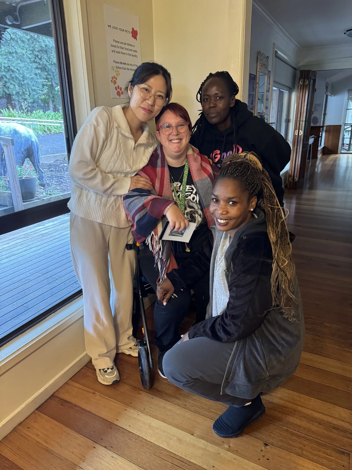 Staff and a resident together in a hallway, smiling for a group photo.