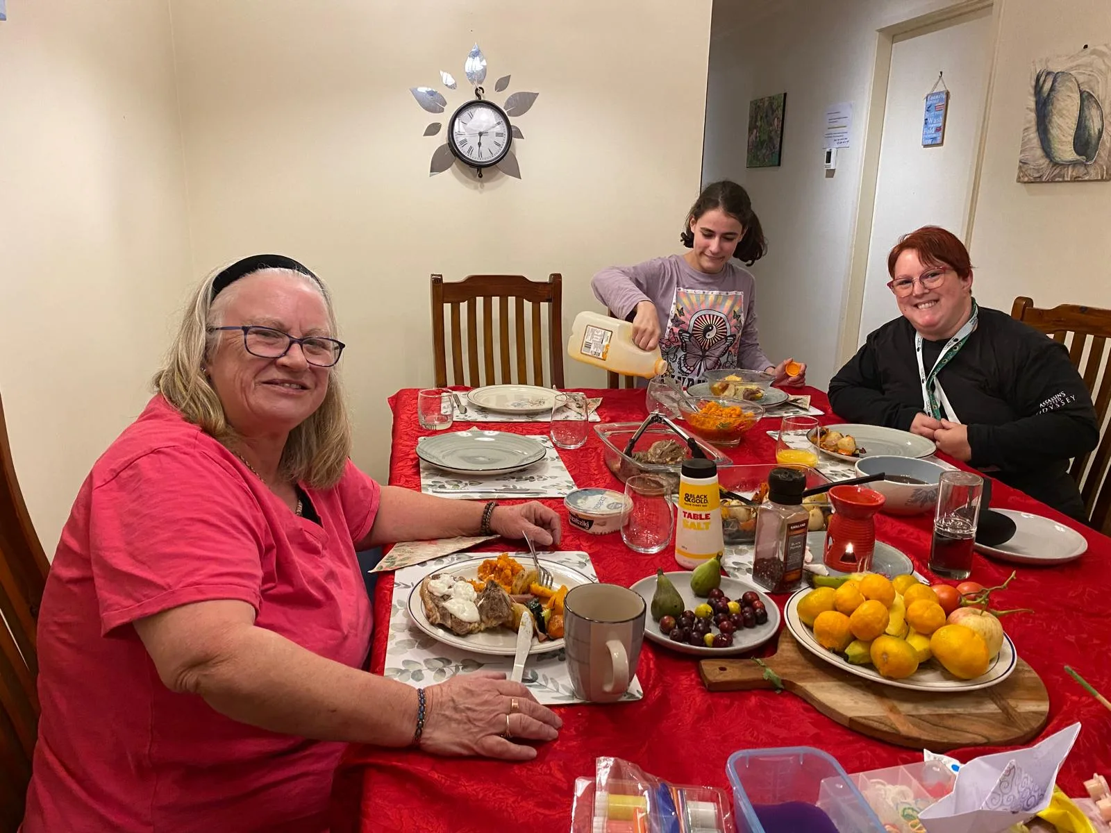 Residents and staff sharing a hearty meal around a dining table.