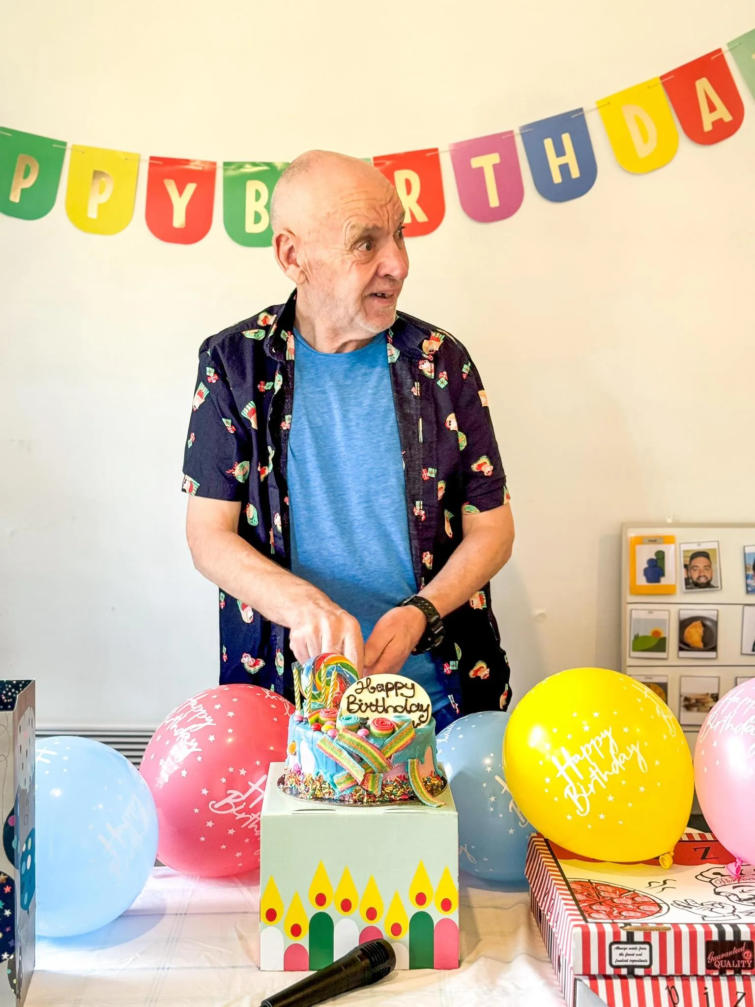 A resident cutting his birthday cake at a party in the home.